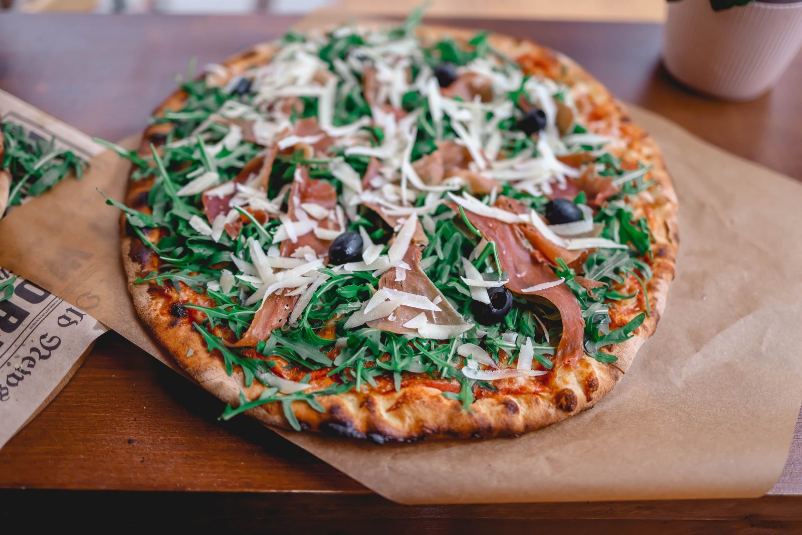 Prosciutto and arugula pizza on a board